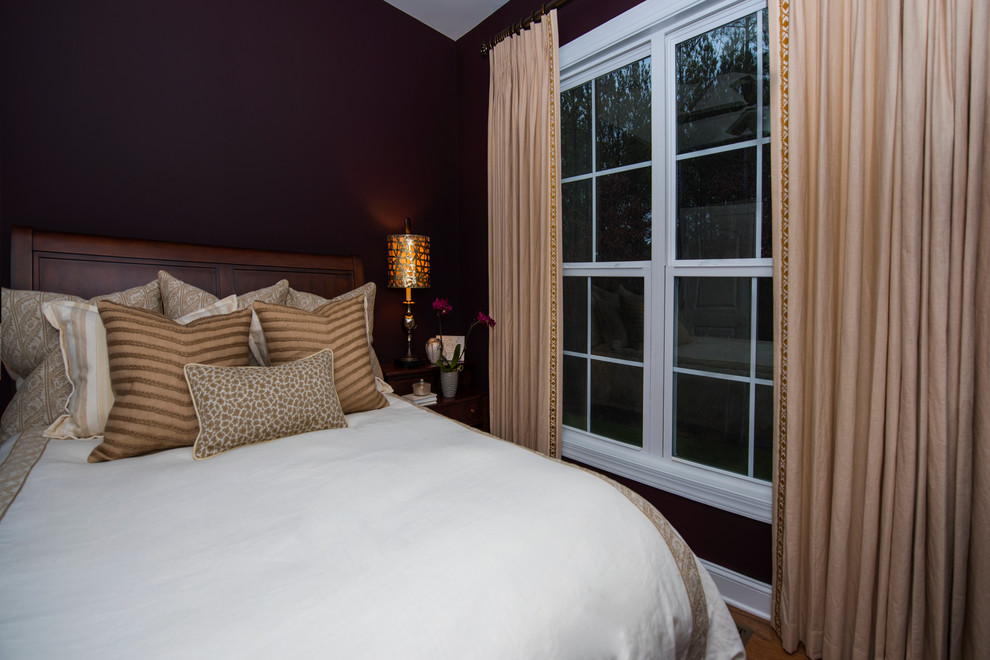 Immagine di una piccola camera degli ospiti classica con pareti viola, pavimento in legno massello medio e nessun camino