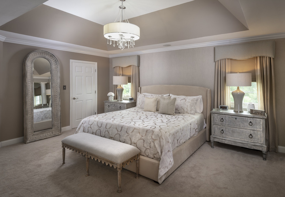 На фото: большая хозяйская спальня в стиле неоклассика (современная классика) с серыми стенами, ковровым покрытием, стандартным камином, фасадом камина из плитки и бежевым полом