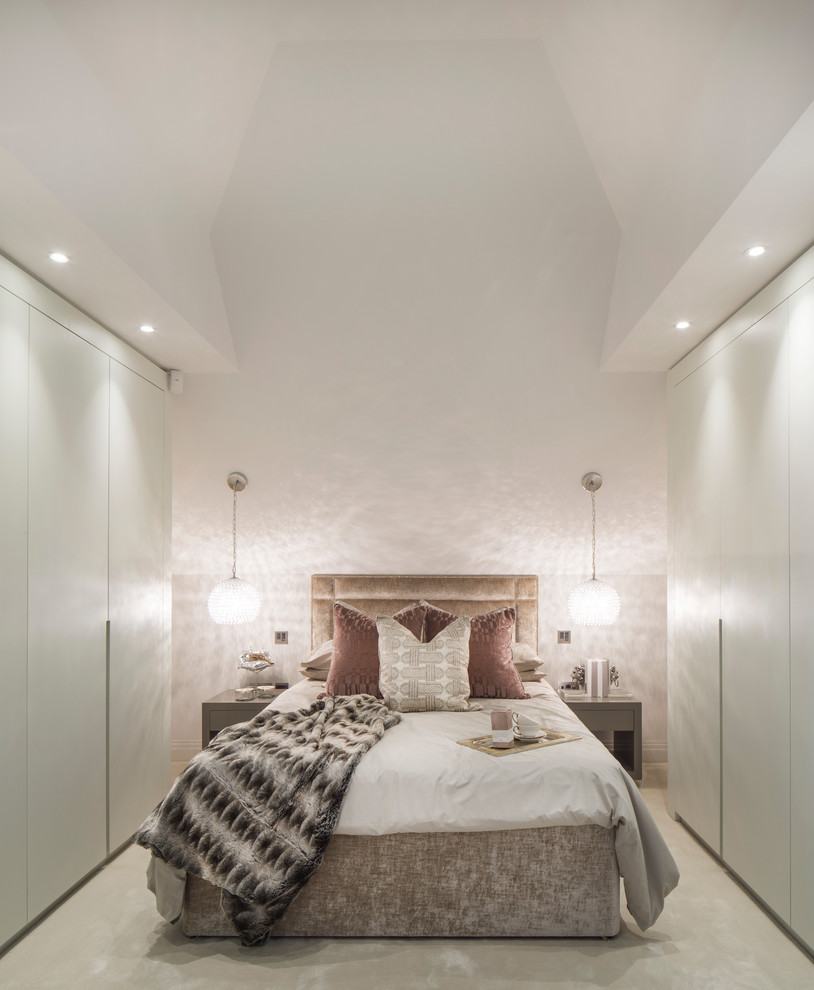 Contemporary master bedroom in London with white walls and carpet.