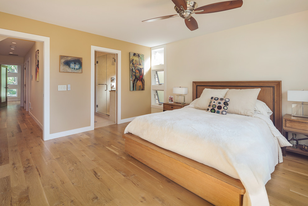 Imagen de dormitorio principal actual con paredes beige y suelo de madera en tonos medios