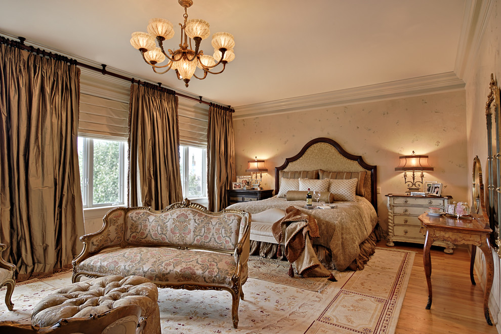 Immagine di una camera da letto chic con pareti beige e parquet chiaro