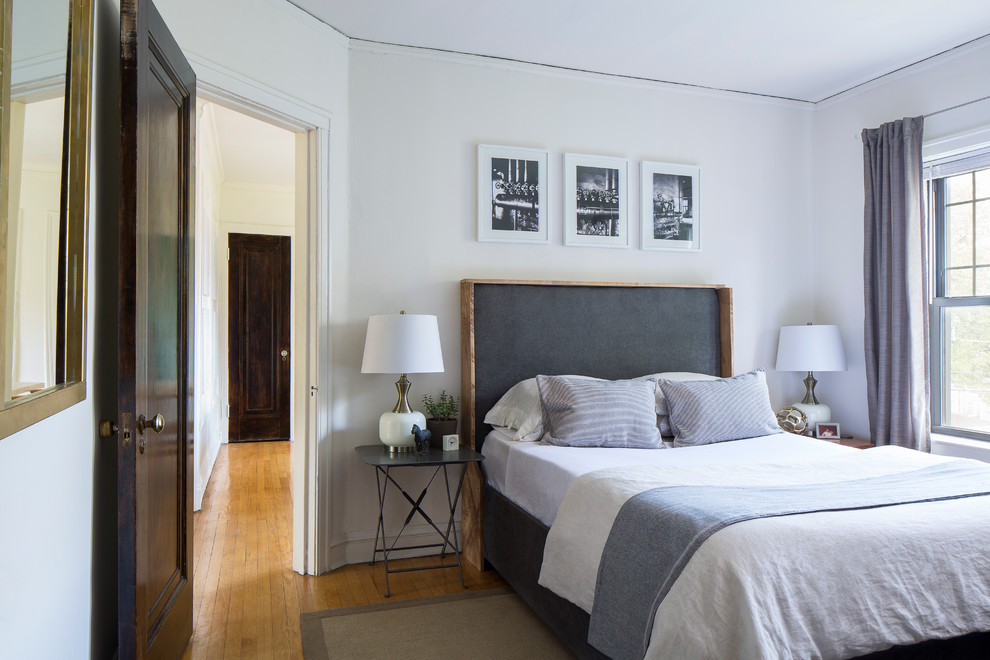 Aménagement d'une petite chambre parentale contemporaine avec un mur blanc, un sol en bois brun et aucune cheminée.