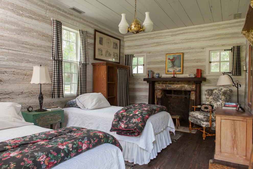 Cette photo montre une chambre d'amis nature avec parquet foncé, une cheminée standard et un manteau de cheminée en brique.