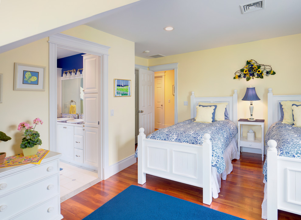 Diseño de habitación de invitados clásica de tamaño medio con paredes amarillas y suelo de madera en tonos medios