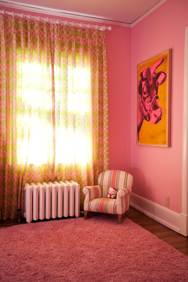 Eklektisk inredning av ett sovrum, med rosa väggar och mellanmörkt trägolv