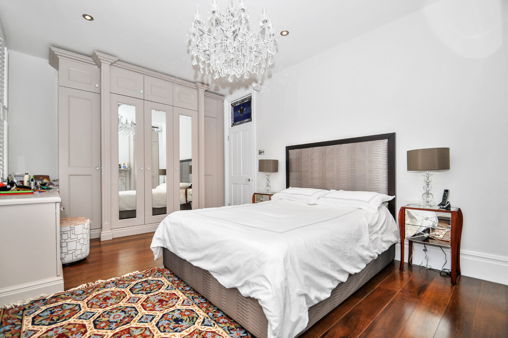 Großes Klassisches Hauptschlafzimmer ohne Kamin mit weißer Wandfarbe und dunklem Holzboden in London