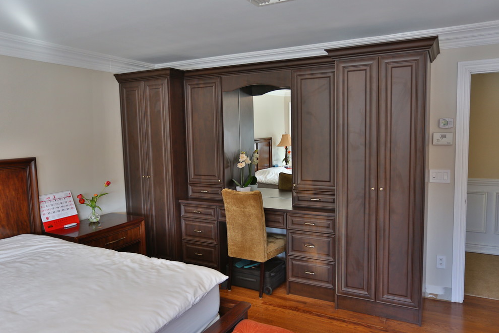 Idée de décoration pour une chambre d'amis tradition de taille moyenne avec un mur beige, un sol en bois brun, aucune cheminée et un sol marron.