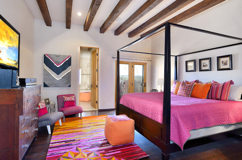 Mediterranes Hauptschlafzimmer mit weißer Wandfarbe, dunklem Holzboden und braunem Boden in Albuquerque