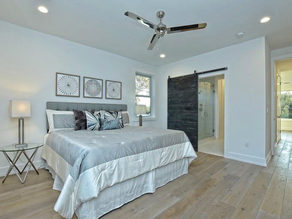 Inspiration for a medium sized farmhouse master bedroom in Austin with white walls and medium hardwood flooring.