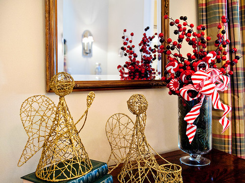 Minimalist wire angel wings with beads wrapped around a white pillar candle for a delicate Christmas touch.