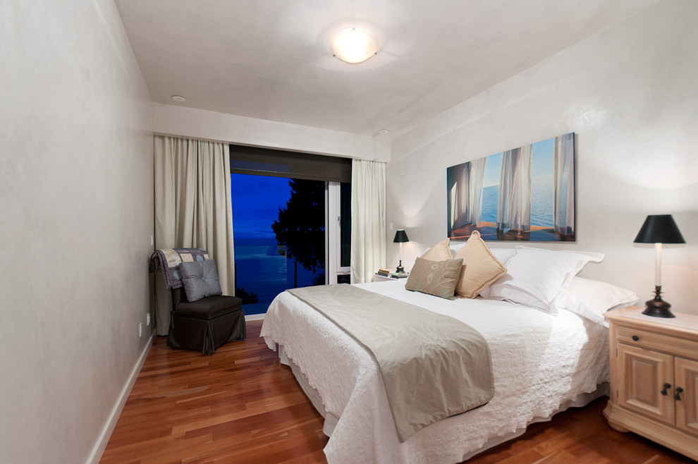 Modelo de habitación de invitados clásica renovada de tamaño medio con paredes blancas y suelo de madera en tonos medios