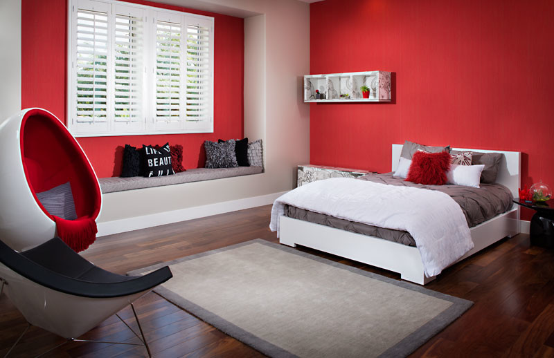 Diseño de habitación de invitados contemporánea grande sin chimenea con paredes rojas y suelo de madera oscura