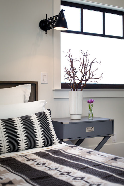 Foto de habitación de invitados urbana de tamaño medio sin chimenea con paredes blancas y suelo de madera en tonos medios