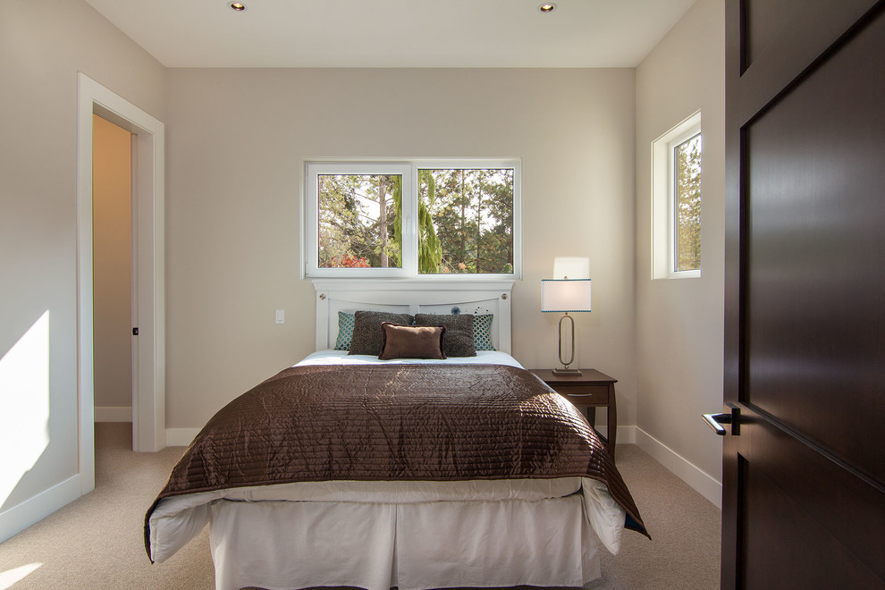 This is an example of a contemporary bedroom in Vancouver with beige walls and carpet.