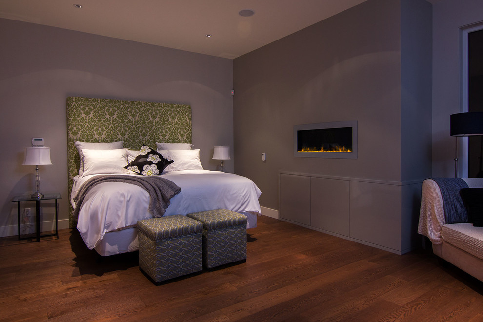 Источник вдохновения для домашнего уюта: спальня в современном стиле с серыми стенами, паркетным полом среднего тона, горизонтальным камином и фасадом камина из металла