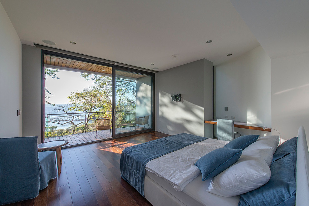 Идея дизайна: гостевая спальня среднего размера, (комната для гостей) в современном стиле с серыми стенами, деревянным полом и коричневым полом