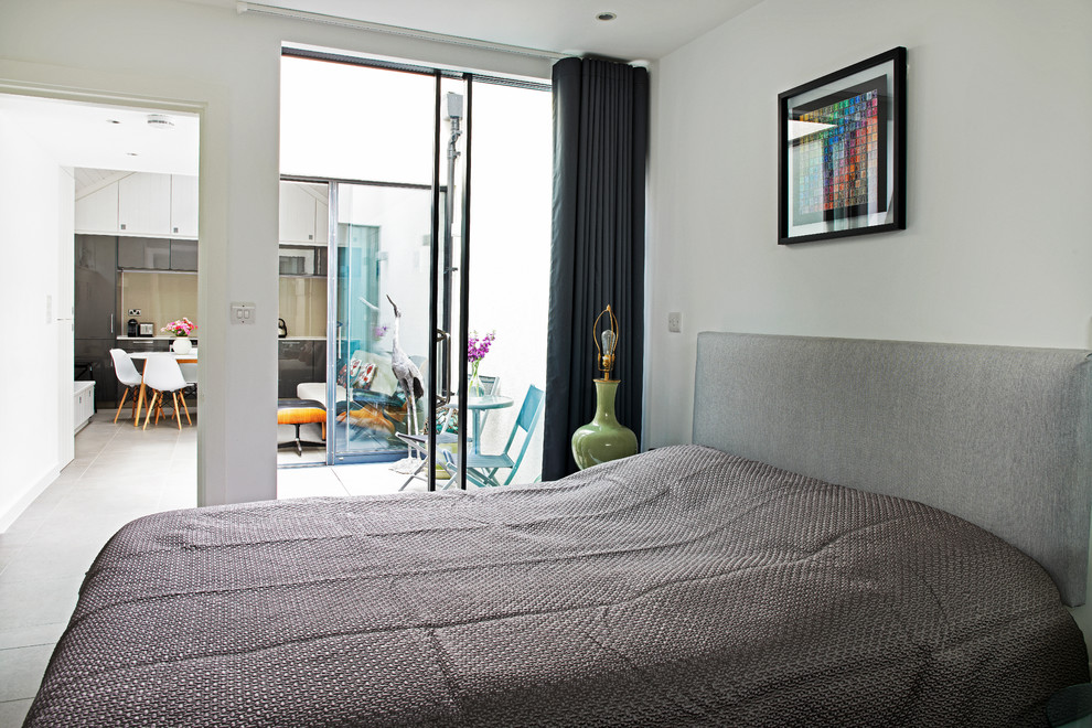 Small contemporary master bedroom in London with white walls, porcelain flooring and no fireplace.