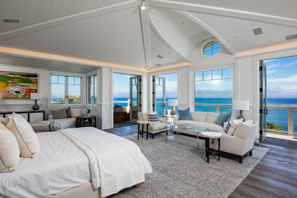 ロサンゼルスにあるビーチスタイルのおしゃれな主寝室 (白い壁、濃色無垢フローリング、茶色い床)
