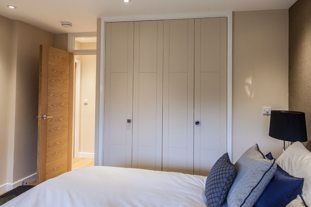 Mittelgroßes Modernes Hauptschlafzimmer mit beiger Wandfarbe und Kalkstein in Surrey