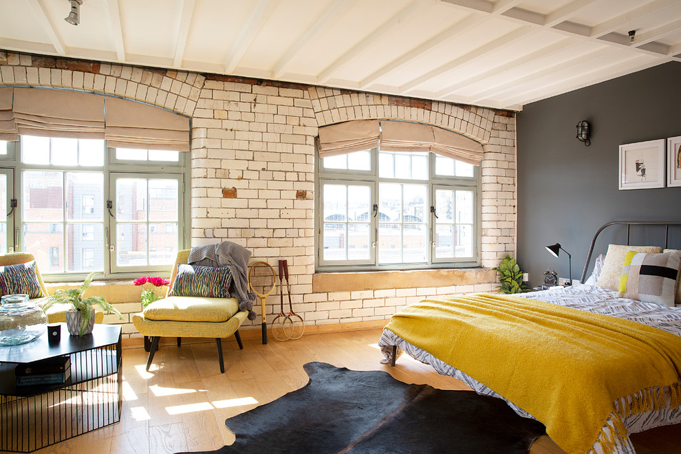 他の地域にある広いインダストリアルスタイルのおしゃれな主寝室 (ベージュの壁、淡色無垢フローリング、ベージュの床) のレイアウト
