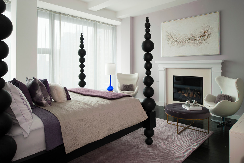Immagine di una camera matrimoniale contemporanea con pareti viola e camino classico