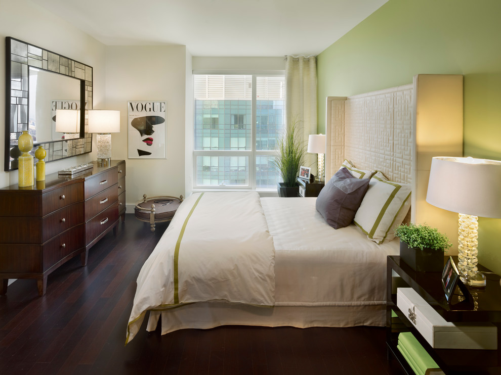 Cette image montre une petite chambre parentale minimaliste avec un mur vert et parquet foncé.