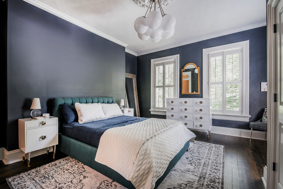 Modelo de dormitorio clásico renovado con paredes azules, suelo de madera oscura y suelo marrón