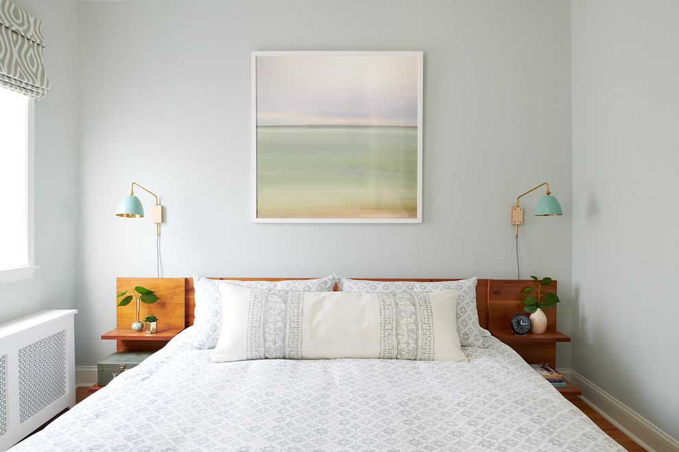 Foto di una camera da letto stile marinaro con pareti blu, pavimento in legno massello medio e pavimento marrone