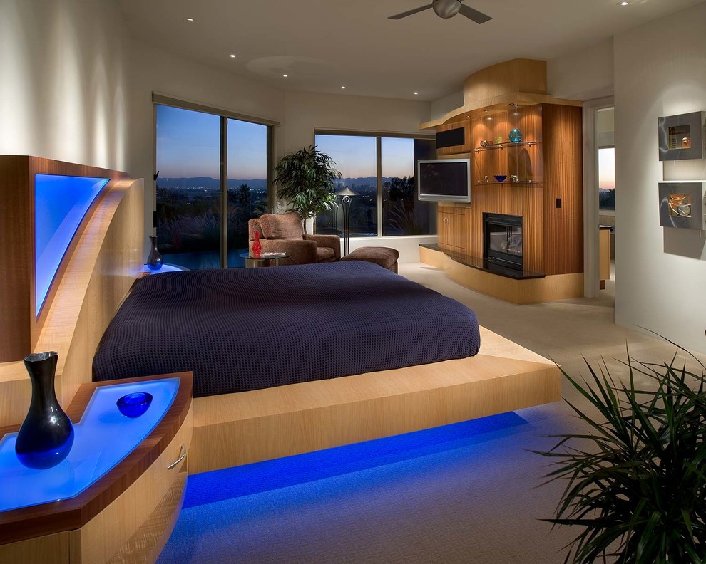 Источник вдохновения для домашнего уюта: спальня в современном стиле с стандартным камином и фасадом камина из дерева