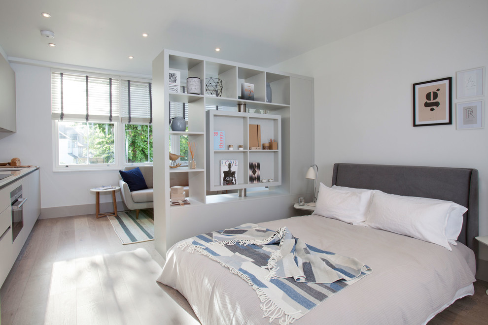 Inspiration for a scandinavian light wood floor bedroom remodel in London with white walls
