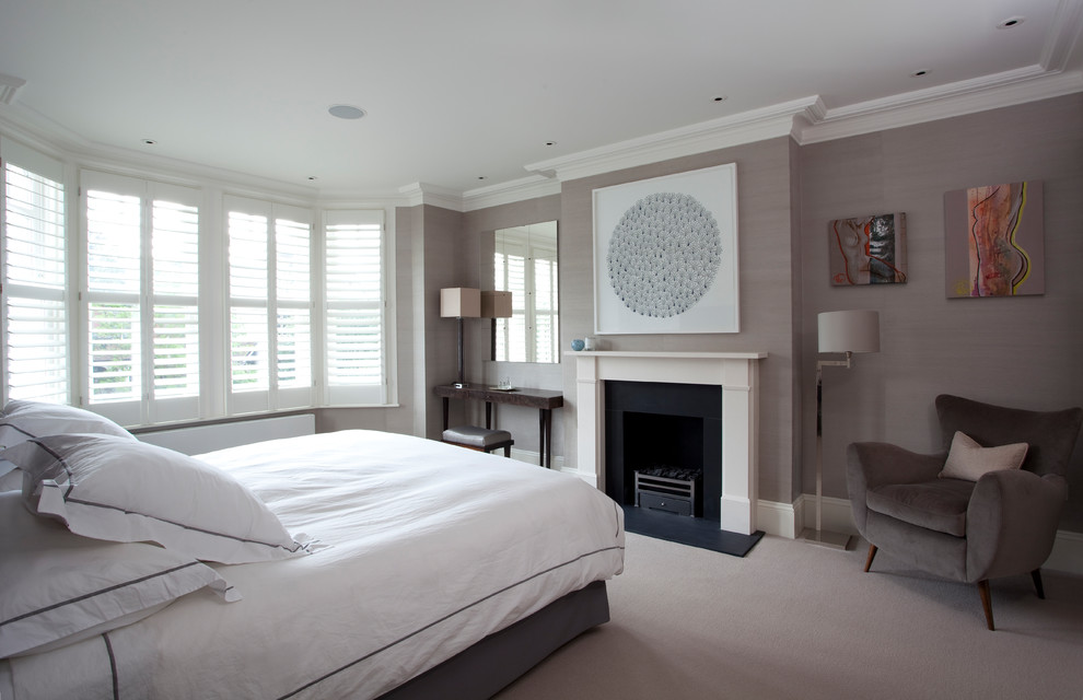 Photo of a medium sized traditional grey and cream bedroom in London with grey walls, carpet, a standard fireplace, a stone fireplace surround and grey floors.