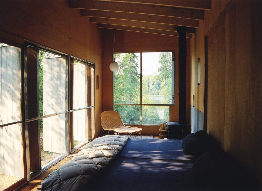Ejemplo de dormitorio tipo loft minimalista pequeño con suelo de contrachapado