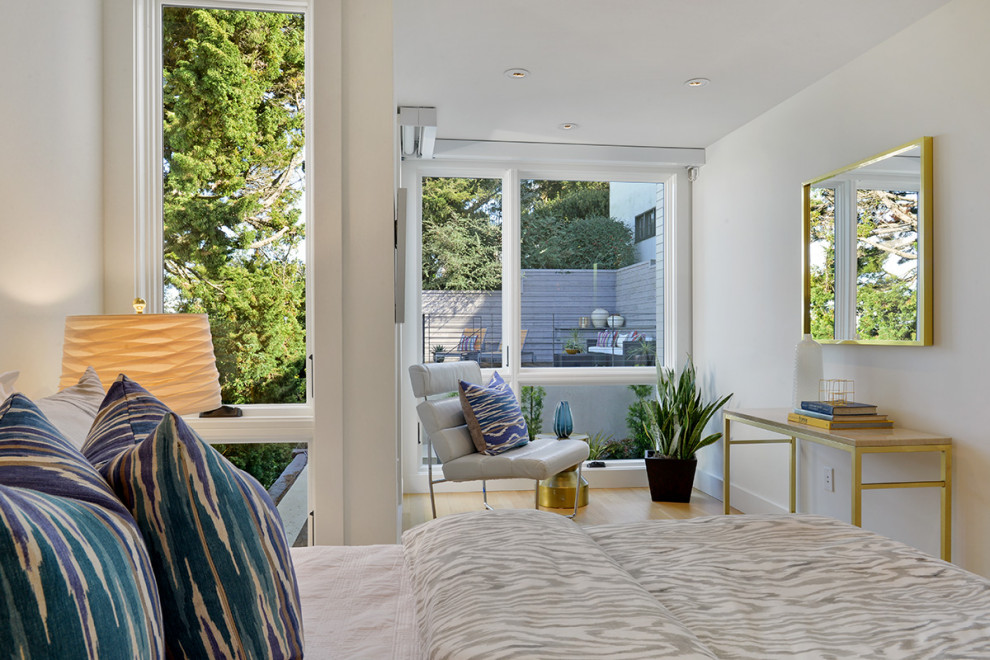 Foto de habitación de invitados moderna de tamaño medio con paredes blancas, suelo de madera clara y suelo beige