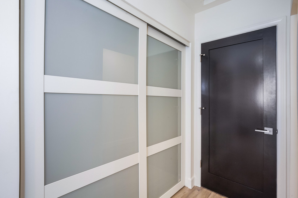 Foto di una camera degli ospiti design con pareti bianche e pavimento in vinile