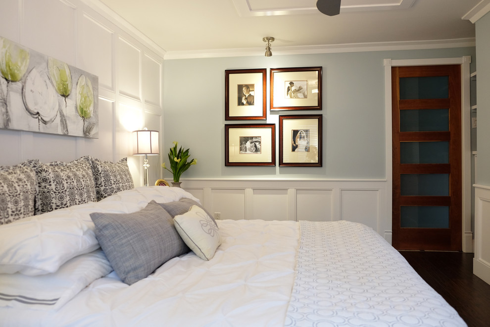 Idée de décoration pour une petite chambre parentale tradition avec un mur gris, parquet foncé, une cheminée standard, un manteau de cheminée en pierre et un sol marron.