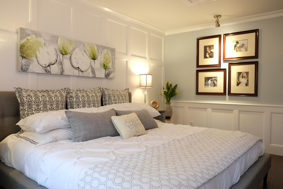モントリオールにある小さなトランジショナルスタイルのおしゃれな主寝室 (グレーの壁、濃色無垢フローリング、標準型暖炉、石材の暖炉まわり、茶色い床、照明)
