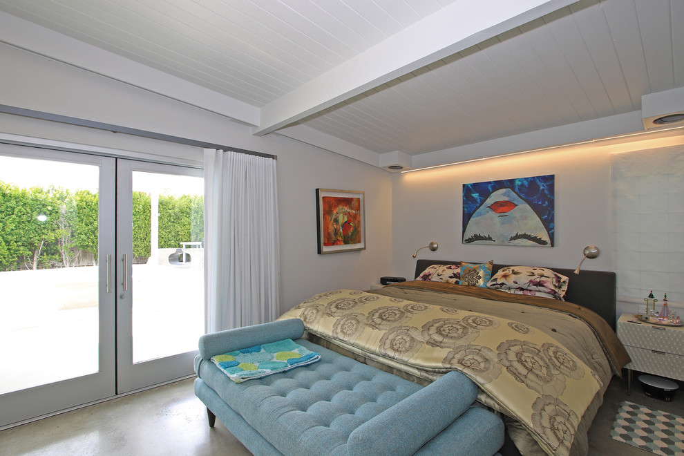 Modelo de dormitorio principal vintage de tamaño medio sin chimenea con paredes blancas, suelo de cemento y suelo gris