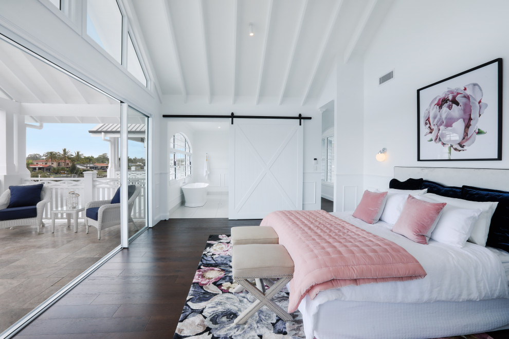 ゴールドコーストにあるビーチスタイルのおしゃれな主寝室 (白い壁、濃色無垢フローリング、茶色い床)