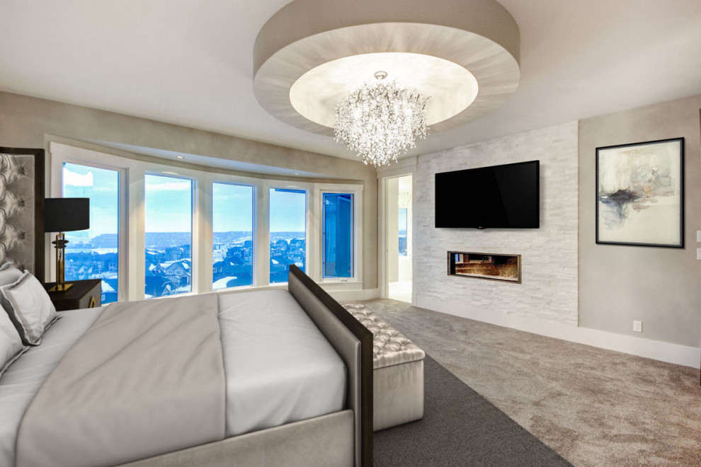 Großes Modernes Hauptschlafzimmer mit grauer Wandfarbe, Teppichboden, Gaskamin, Kaminumrandung aus Stein und beigem Boden in Calgary