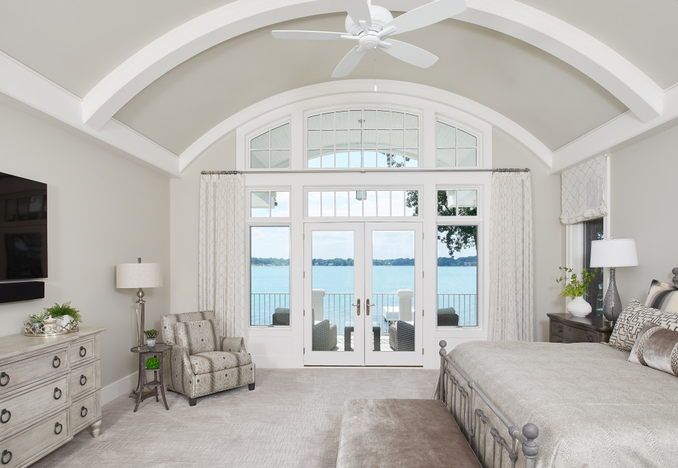 Ejemplo de dormitorio principal y abovedado marinero grande con paredes beige, moqueta y suelo beige