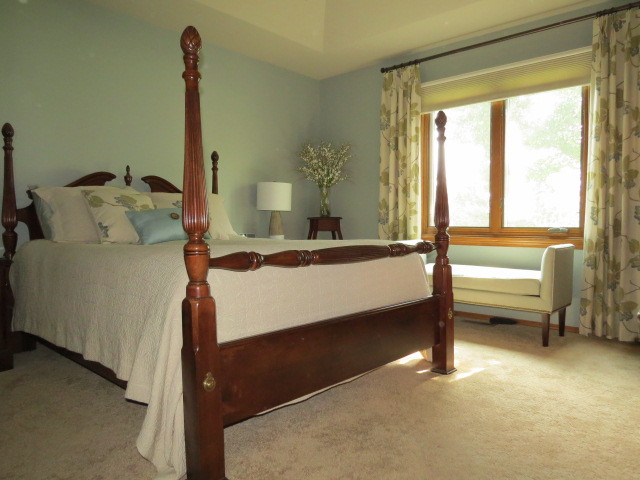 Modelo de dormitorio principal tradicional de tamaño medio sin chimenea con paredes azules, moqueta y suelo beige