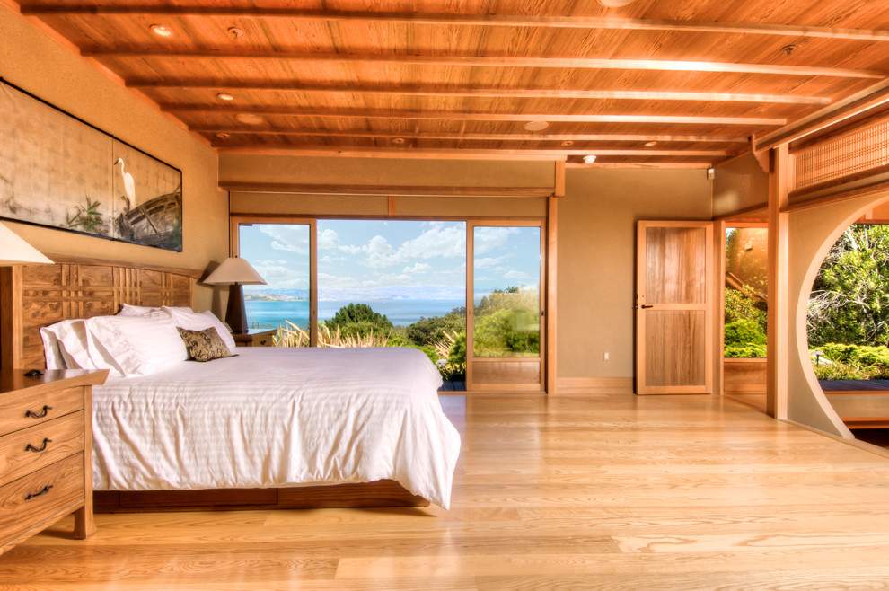 Large world-inspired master bedroom in San Francisco with beige walls and medium hardwood flooring.
