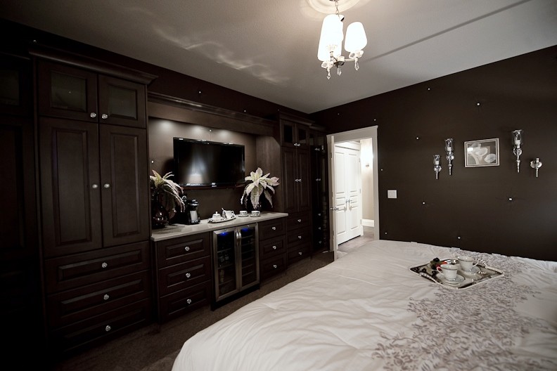 Modelo de dormitorio principal clásico grande con paredes marrones y moqueta
