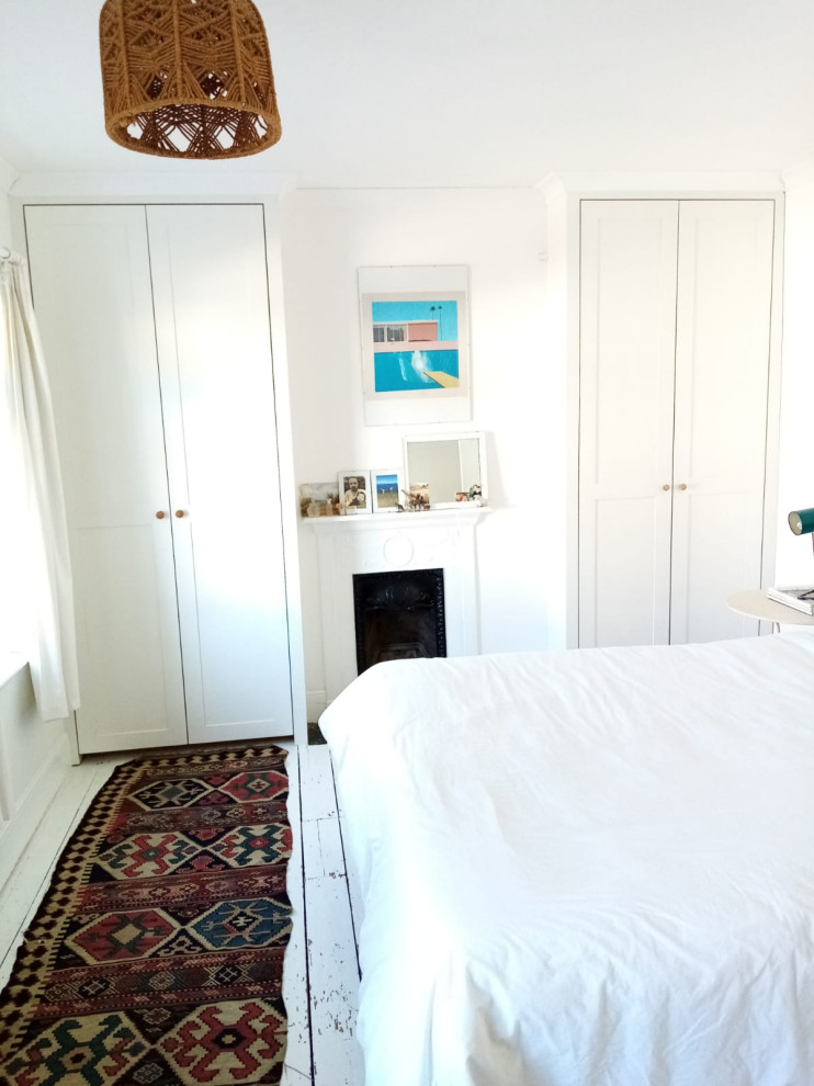 Cette photo montre une chambre parentale bord de mer de taille moyenne avec un mur blanc, parquet peint et un sol blanc.