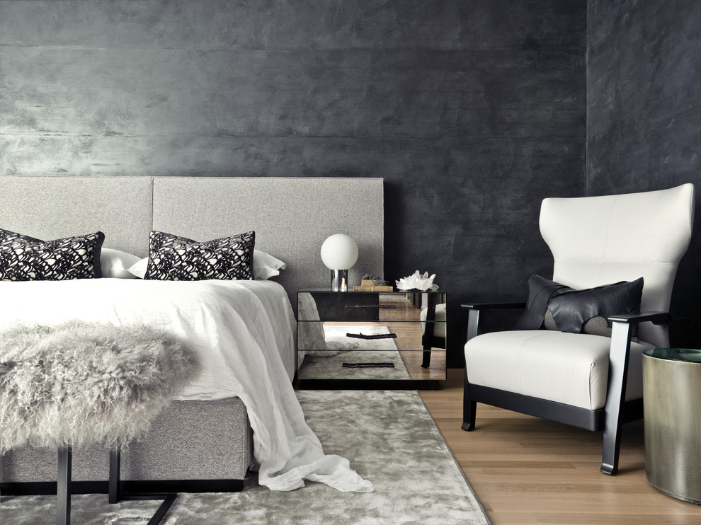Immagine di una camera da letto contemporanea con pareti nere e parquet chiaro