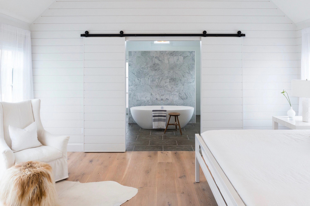 Esempio di una piccola camera matrimoniale minimalista con pareti bianche e parquet chiaro