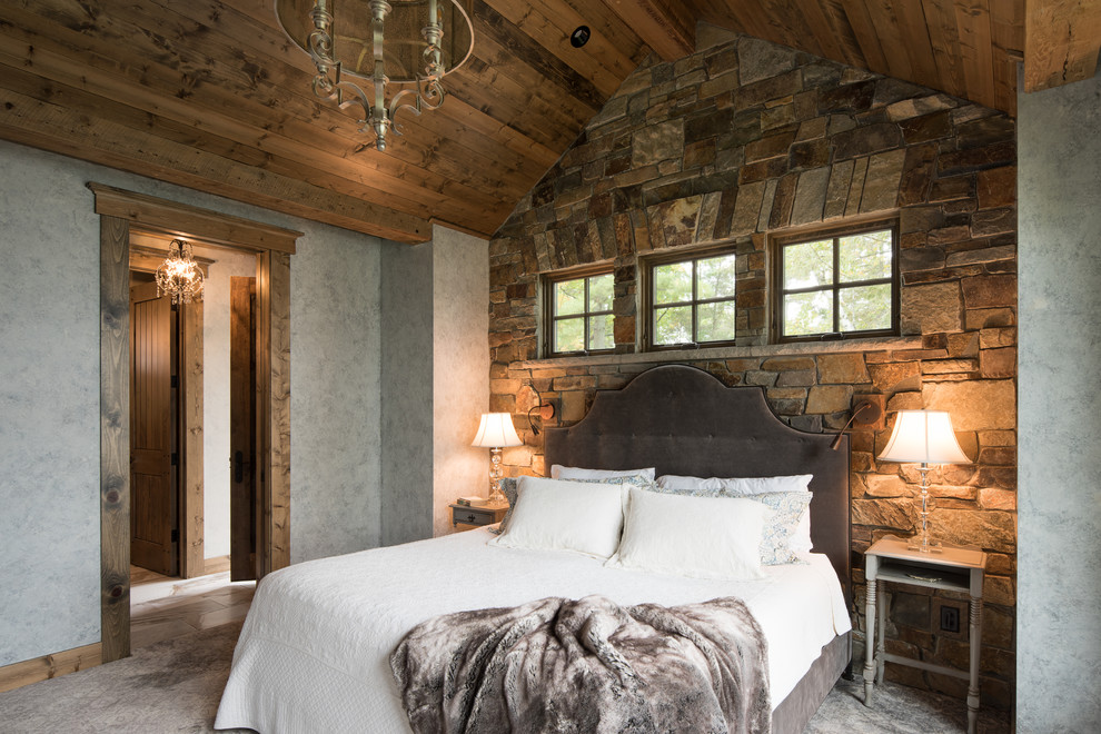 Photo of a rustic master bedroom in Minneapolis with grey walls and grey floors.
