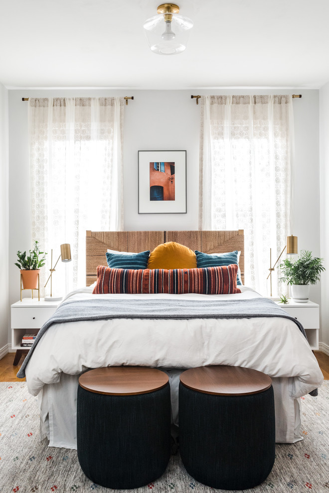 ボストンにあるトロピカルスタイルのおしゃれな寝室 (白い壁、無垢フローリング、茶色い床、照明、グレーとブラウン) のインテリア