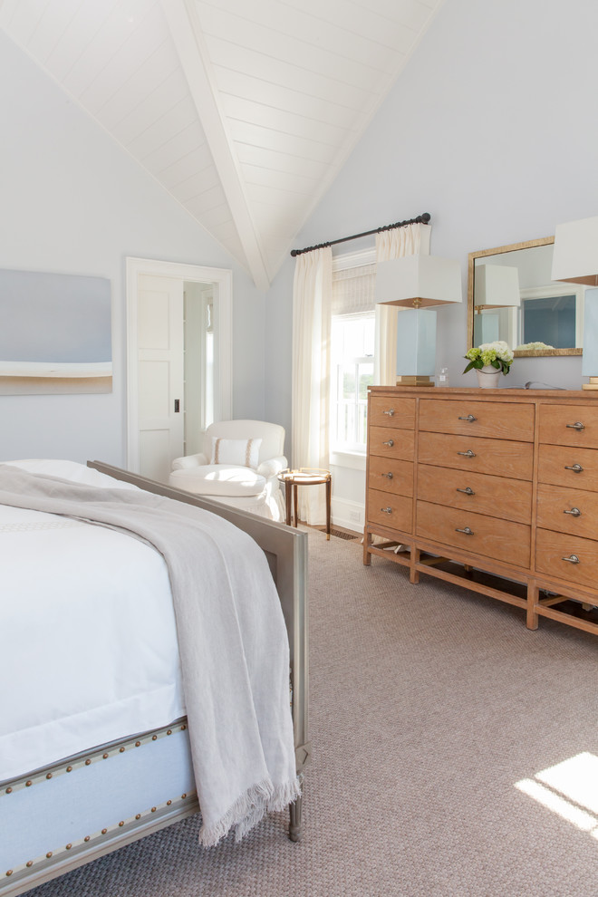 Imagen de dormitorio principal costero grande sin chimenea con paredes azules, moqueta y suelo beige
