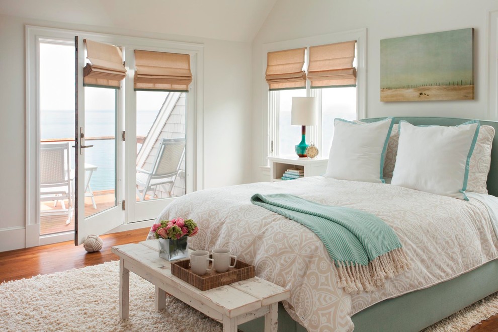 Cette photo montre une chambre parentale bord de mer de taille moyenne avec un mur blanc et un sol en bois brun.